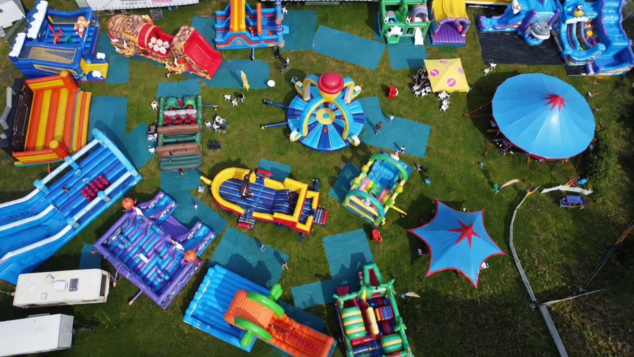 Luftaufnahme des Fun City Parks mit bunten Hüpfburgen, Rutschen und Zelten