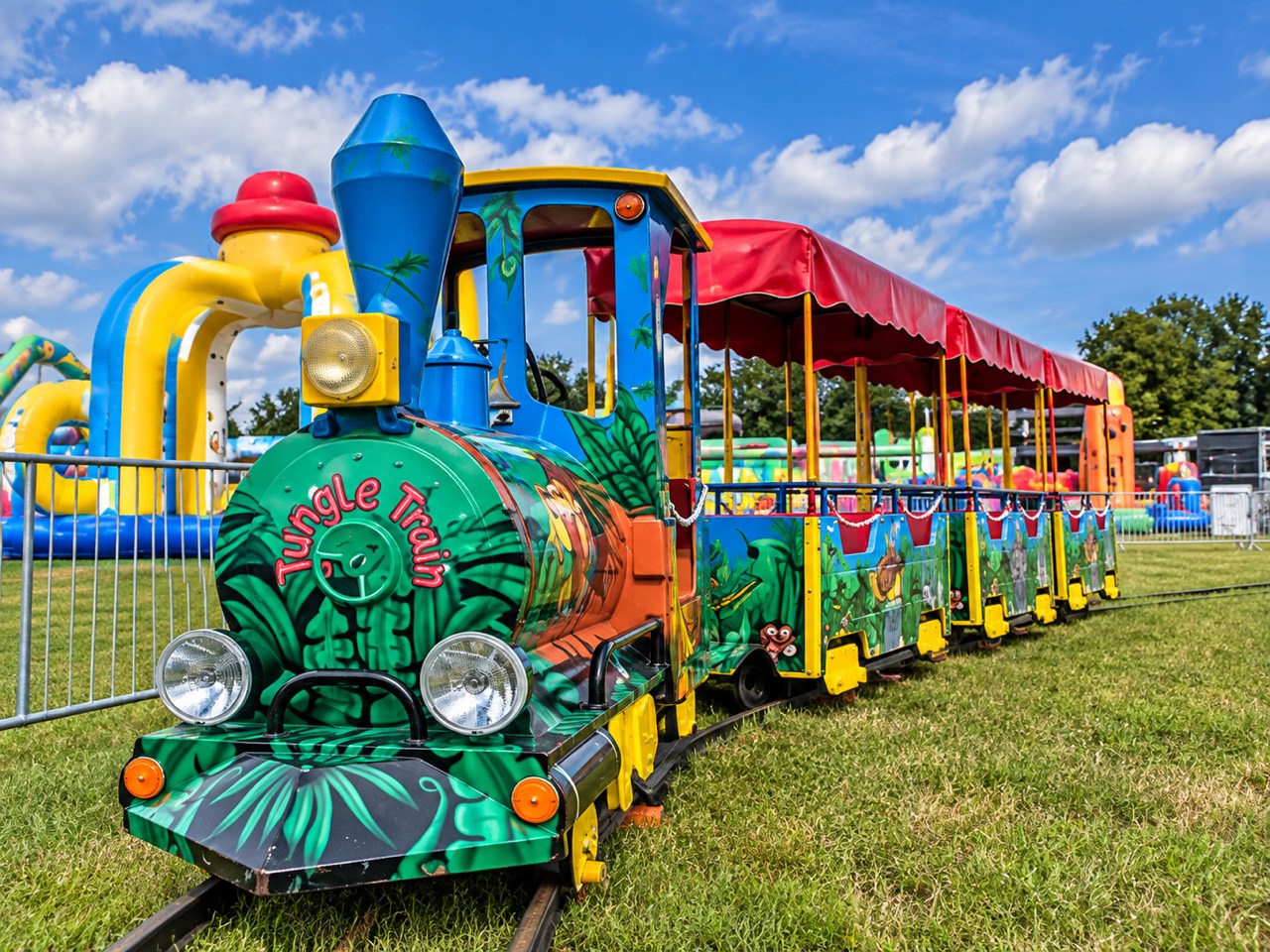 Bunte Kindereisenbahn Jungle Train mit Dschungelmotiven und roten Wagendächern